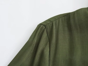 Detail of dark green fabric texture and shoulder stitching on casual Y2K loose shirt