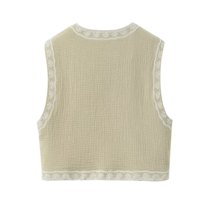 Vue détaillée de la broderie florale sur le gilet en coton texturé vert clair sans manches
