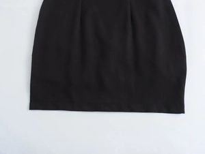 Vue détaillée de l'ourlet cousu plat sur une robe dos nu noire sexy en tissu tissé