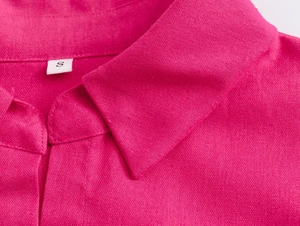 Macro detail of breathable textured fabric on dark pink shirt with classic collar and S size tag
