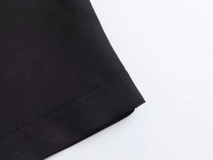 Gros plan détaillé de la texture du tissu noir tissé et des coutures sur une robe d'été