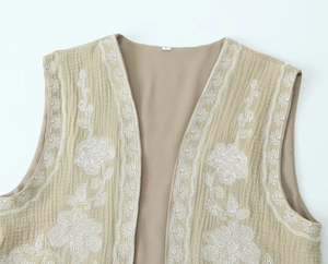 Détail de la broderie florale sur le gilet kaki avec texture du tissu et étiquette