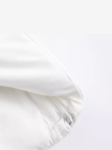 White halter top featuring a designer bow detail and a polished silver metal logo buckle
