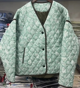 Dettaglio della giacca trapuntata verde menta con motivi paisley e bordi marroni