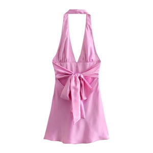 Dettaglio dell'abito in raso rosa con scollo all'americana e grande fiocco sul retro