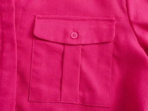 Detail view of rose pink textured shirt featuring utility flap pocket with resin button