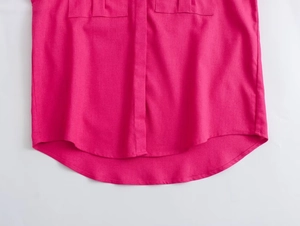 Detailed view of the curved hem and pocket flaps on this hot pink casual blouse