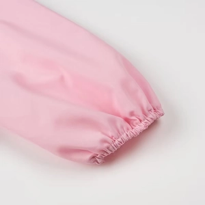 Detailed close-up of elastic cuffs and silky pink fabric on a stylish long sleeve shirt