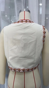 Detailed close-up of multi-color floral embroidery on vintage white sleeveless vest