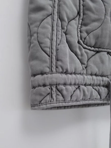 Dettaglio dell'imbottitura curva e del cotone twill sull'orlo del gilet grigio scuro