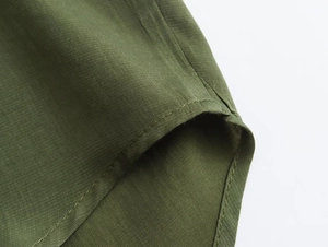 Detailed close-up of dark green woven fabric showing high-quality stitching and texture