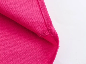 Close-up detail of rose red casual shirt fabric texture and neat overlock stitching seam