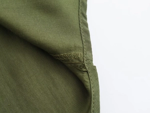 Detail view of the olive green cotton fabric with precise stitching and overlock seams