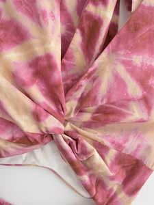 Detail of summer halter dress featuring tie-dye pattern and central knot design element