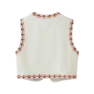 Detailed view of white ribbed fabric vest with vibrant floral embroidery on the edges