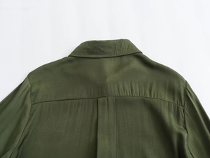 Detail view of olive green shirt collar and shoulder stitching with textured cotton fabric