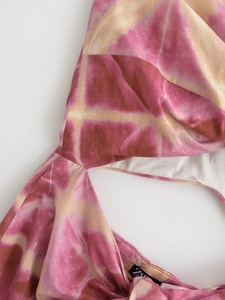 Detail of pink tie-dye fabric texture and branded collar label on a summer dress