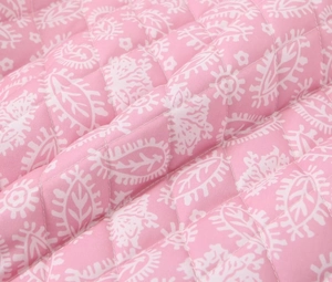 Dettaglio del tessuto trapuntato rosa con motivi paisley e cuciture a rombi di alta qualità