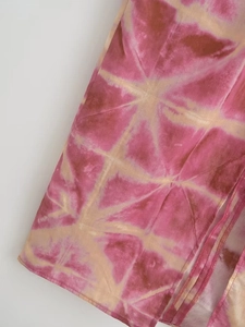 Close-up of pink tie-dye pattern on summer halter dress with refined stitching detail