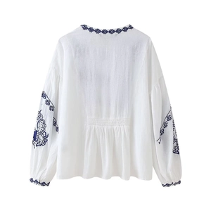 Broderies détaillées et taille élastique au dos d'une blouse blanche en lin