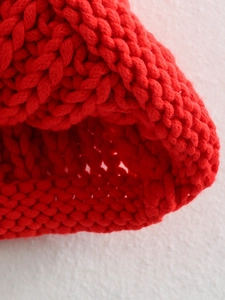 Coarse knit red wool beanie with thick texture and ribbed design for winter warmth