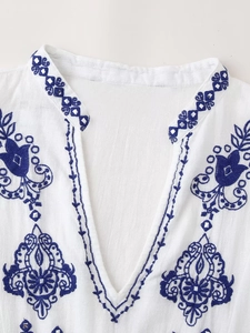 Blouse bohème blanche à col en V avec broderie florale bleu marine et paillettes argentées