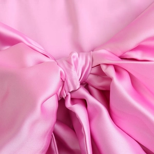 Dettaglio ravvicinato di un fiocco di raso rosa con lucentezza e trama elegante