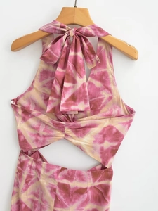 Detail of summer halter dress featuring pink geometric tie-dye print and knot design