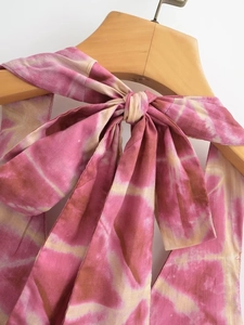 Close-up of pink tie-dye dress featuring a delicate halter neck tie with a large bow detail
