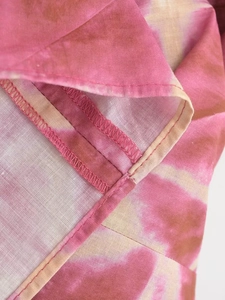 Detailed macro view of the tie-dye fabric stitching and inner overlock seam finish