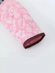 Dettaglio giacca trapuntata rosa con motivo paisley e bordo in tessuto rosso scuro