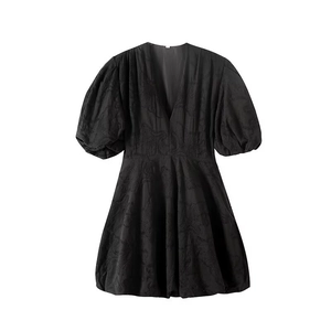 Détail de la robe noire à manches bouffantes en tissu jacquard fleuri et décolleté en V