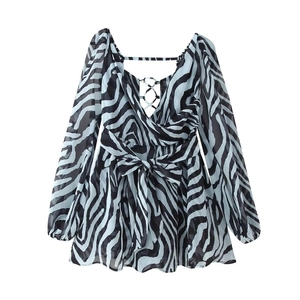 Détail de robe mini zébrée bleue avec décolleté en V profond, manches bouffantes et taille