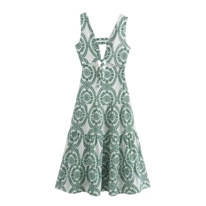 Close-up of white cutout mini dress featuring green leaf embroidery and knot detail