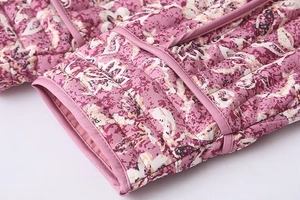 Detailed close-up of quilted cuffs on a purple floral cotton jacket with fine stitching