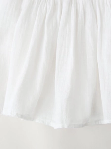 Blouse d'été col en V en coton blanc avec des détails de plis verticaux et broderies