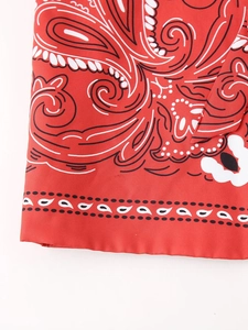 Macro view of red paisley pattern on cotton vest fabric with intricate print detail