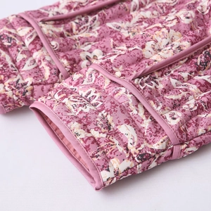 Close-up of floral quilted jacket sleeve with neat stitching and vertical texture