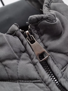 Detail of high-quality metal zipper and diamond quilted pattern on winter cotton jacket