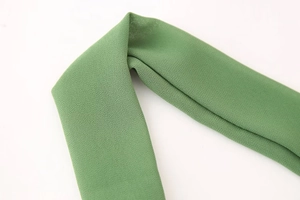 Gros plan sur le tissu en maille de mousseline verte montrant la texture et la sangle