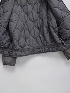 Dark gray quilted winter jacket with stand collar and detailed wavy stitching patterns
