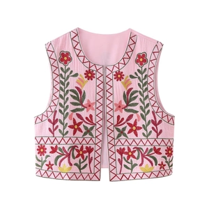 Close-up of pink embroidered vest featuring bohemian floral patterns and cotton texture