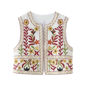 Close-up of colorful floral embroidery and textured fabric on a white Y2K vest