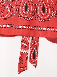 Detailed macro view of red paisley print fabric with adjustable hem drawstrings
