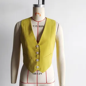 Detail showing the mustard yellow V-neck vest with four white buttons and slim fit cut