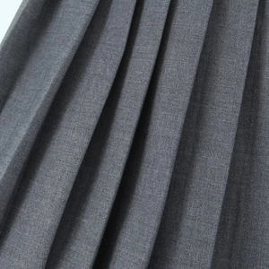 Detail shot of the pleated dark gray skirt showing high-quality twill fabric and neat pleats