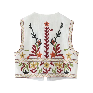 Detailed view of bohemian floral embroidery on the back of a white cropped vest