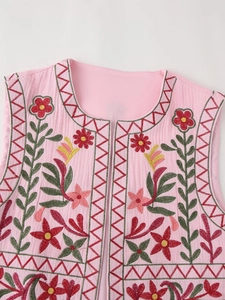 Detailed close-up of pink Y2K embroidered vest with floral patterns and geometric edges