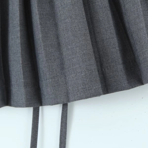 Close-up of gray pleated skirt featuring fine twill fabric and neat stitching detail