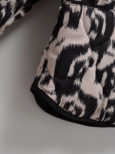 Détail d'une veste matelassée à losanges avec imprimé animal abstrait noir et blanc